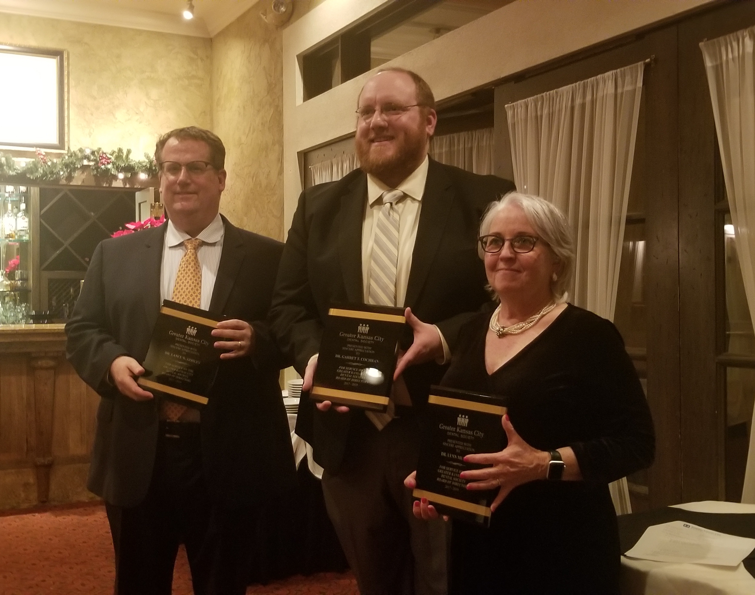 Three people with plaques